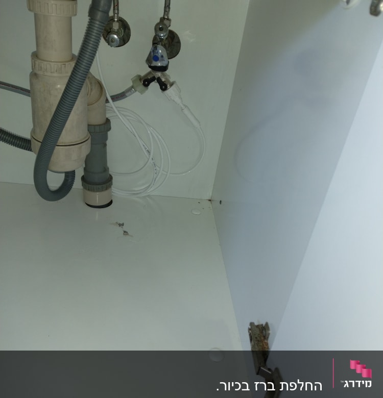 צנרת מתחת לכיור עם ברזים וצינורות